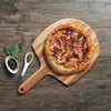 This is a picture of a yummy pizza on a wooden pizza paddle from the ultimate home pizza experience gift basket.