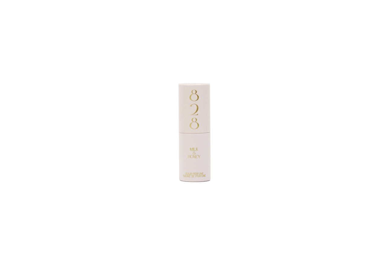 White lipstick with gold accents on a light gray background