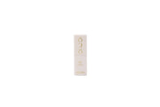 White lipstick with gold accents on a light gray background