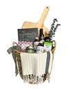 This is a picture of a Home Pizza Gift Basket. There's a personalized wooden pizza paddle, infused olive oil, balsamic glaze, gourmet bbq sauces, herb sea salt, a game of charades and "The Elements of Pizza" cookbook.