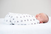XO muslin swaddle blanket on baby