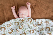 sloth muslin swaddle blanket on baby
